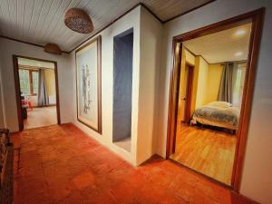 einen Flur mit einem Zimmer mit einem Bett und einem Spiegel in der Unterkunft Finca Agrreste in Nemocón
