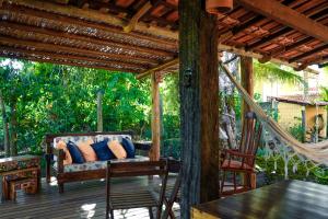 a porch with a couch on a wooden deck at Cais Dourado Pousada in Barra Grande