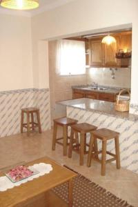 eine Küche mit einem Tisch, Stühlen und einer Theke in der Unterkunft Casas do Castelo in Aldeia da Serra