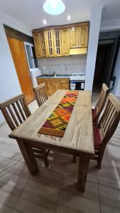 mesa de madera con 2 sillas y cocina en La Casa de Lili en San Rafael