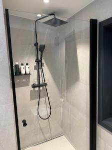 y baño con cabina de ducha con cabezal de ducha. en Cabin in Tromsø en Tromsø