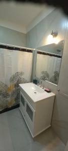 Un baño blanco con lavabo y espejo. en Colon Suites 2. Duplex a 18 minutos Aeropuerto Ezeiza, en Monte Grande 12 fotos más