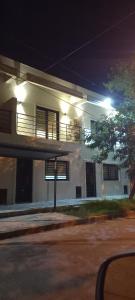 una casa blanca con balcón por la noche en Colon Suites 2. Duplex a 18 minutos Aeropuerto Ezeiza, en Monte Grande