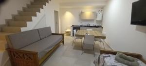 Una sala de estar con un sofá y una mesa y una cocina. en Colon Suites 2. Duplex a 18 minutos Aeropuerto Ezeiza, en Monte Grande