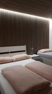 メッツィンゲンにあるアパート メッツィンゲン パノラマブリックのベッドルーム1室(ピンクの枕が付くベッド2台付)
