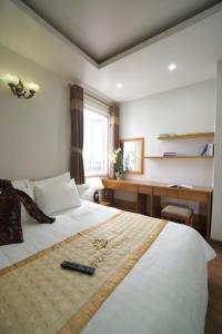 Trang Thanh Luxury Apartment في هاي فونج: غرفة نوم مع سرير مع ريموت كنترول عليه