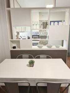 una mesa blanca y sillas en una cocina en Bauza Ribot Departamento Boutique en Mendoza en Mendoza