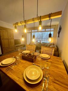 einen Holztisch mit Tellern und Weingläsern darauf in der Unterkunft Mountain Lodge in Sankt Andreasberg