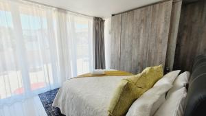 ein Schlafzimmer mit einem Bett und einem großen Fenster in der Unterkunft Effortless Self Catering Accommodation in East London