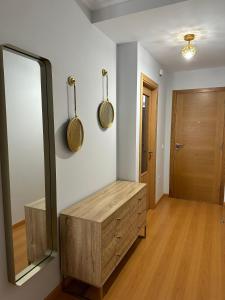 een kleedkamer met een spiegel en een houten dressoir bij Apartamento Ría de Arousa in Boiro