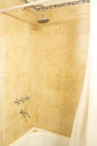 a shower with a white shower curtain and a tub at Calida casa ph, con patio in Florida