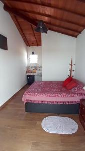 1 dormitorio con 1 cama con colcha roja en Morada do Canal Suites em Búzios, en Búzios