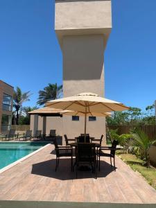 a patio with a table and umbrella next to a pool at Taipu Lodge Beach in Marau