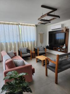 a living room with couches and a flat screen tv at Taipu Lodge Beach in Marau