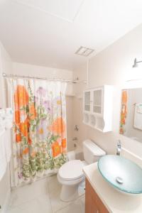 a bathroom with a toilet and a shower curtain at Aloha Nui Loa in Kahuku