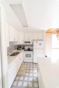 uma cozinha branca com um lavatório e um frigorífico em Turtle Bay Sage TA-097-866-3424-02 condo em Kahuku