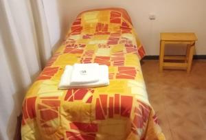 Una cama con un edredón con un libro. en Departamento Del Sol (Esquel-Chubut) en Esquel