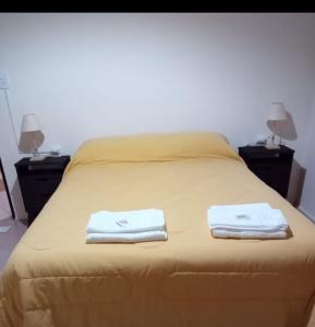 1 dormitorio con 1 cama con 2 toallas en Departamento Del Sol (Esquel-Chubut) en Esquel