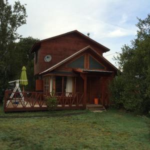 a small house with a deck and a umbrella at Pucón La Tita in Pucón