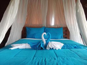 two swans made out of towels on a bed at Dreamy Eco Tree House by 7 Waterfalls in Ambengan