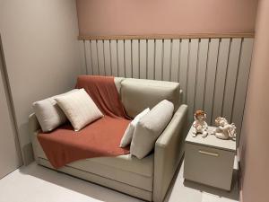 um quarto para crianças com um berço com uma cadeira e bonecas em Flat novo no Eco Resort em Tamandaré