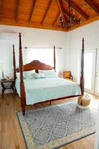 1 dormitorio con cama con dosel y alfombra en Blue Love Point 3BR home en Gregory Town