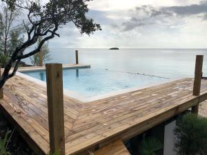 a swimming pool on a wooden deck next to the water at Savannah Sunset home in Savannah Sound