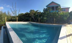 a swimming pool in front of a house at Savannah Sunset home in Savannah Sound