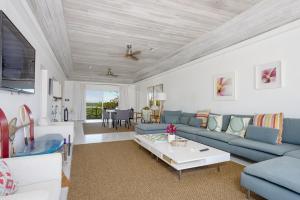 a living room with a blue couch and a table at Utopia House home in Savannah Sound