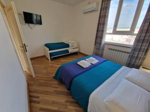 een kleine slaapkamer met een bed en een stoel bij B&B FR House Affittacamere Colleferro in Colleferro