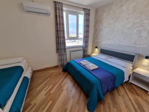 a bedroom with a blue bed and a window at B&B FR House Affittacamere Colleferro in Colleferro