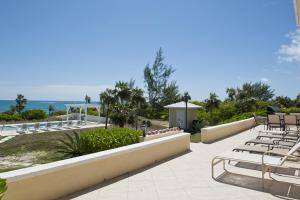 a patio with chairs and tables and the ocean at Endless Summer home in Savannah Sound