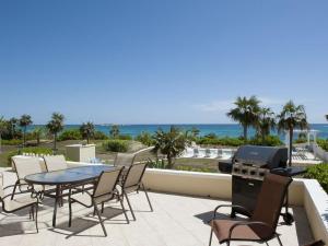 a patio with a table and chairs and the ocean at Endless Summer home in Savannah Sound