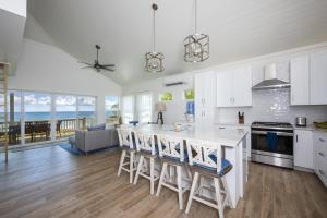 a kitchen with white cabinets and a table and chairs at Lavender Beach House home in James Cistern