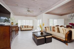 a large living room with a couch and a tv at Long Island Breeze Compound home in Nassau