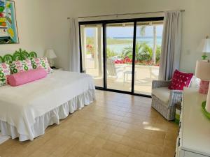 - une chambre avec un lit et une vue sur l'océan dans l'établissement Halcyon House home, à Savannah Sound