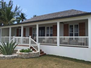 a house with a white deck and porch at French Leave South Beach Dogtrot Villa villa in Governorʼs Harbour