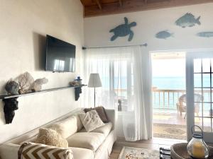 a living room with a couch and a view of the ocean at Blue Love Point home in Gregory Town