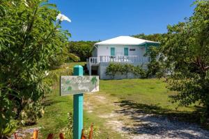 a sign in front of a white house at Key Lime Cottage home in Hatchet Bay Limited Settlement