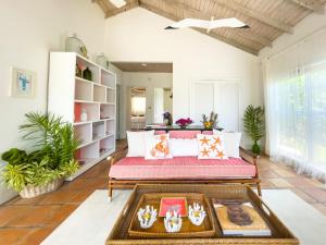 a living room with a couch and a table at Folly Guest House cottage in Governorʼs Harbour