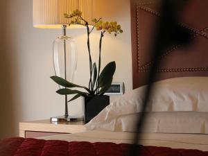 a bedroom with a bed with a lamp and a vase with flowers at Hotel Cristallo in Giulianova