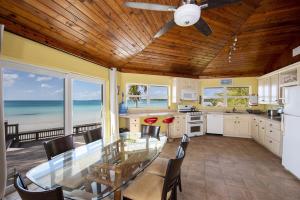 a kitchen with a dining table and a view of the ocean at Sand Dollar at Ten Bay Beach home in Savannah Sound
