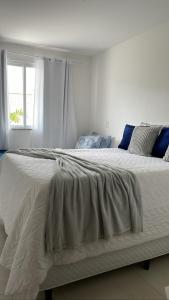a large white bed in a bedroom with a window at Le Bon Vivant - Praia Grande - Arraial do Cabo in Arraial do Cabo