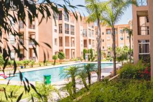 kompleks apartamentów z basenem i palmami w obiekcie Ricoflores PALM w mieście Benslimane