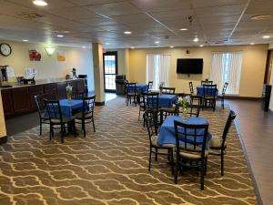 a dining room with blue tables and chairs and a screen at Americas Best Value Inn Pharr/McAllen in Pharr