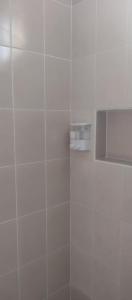 a white tiled shower with a soap dispenser at Estudio a 15 min caminando de la terminal de autobuses ADO in Cancún