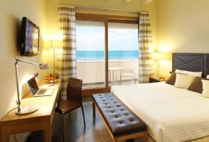 a bedroom with a bed and a desk and a window at Hotel Cristallo in Giulianova
