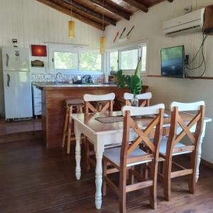 cocina con mesa, sillas y nevera en cabaña valhalla delta en tigre en Dique Luján