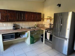 a kitchen with a stainless steel refrigerator and wooden cabinets at Casa arroyo at Bajazul just steps of waterfront and downtown in Loreto