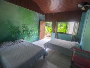 a bedroom with two beds and a painting on the wall at La Katalinda in Drake